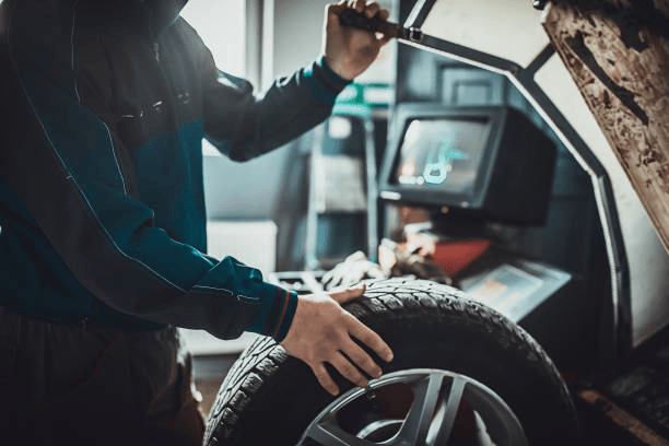 Technician balancing tire on machine